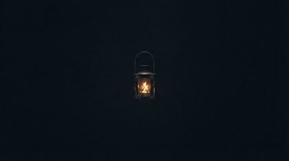 A single small lantern of dark metal floats in a vast, cold, utterly dark cosmic void, glowing from within with a warm, gentle, candle-like golden flame — the only point of warmth in an endless indifferent darkness, a fragile pocket of hope.